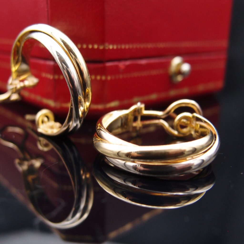 BOUCLES D’OREILLES CARTIER TRINITY, OR 18 CARATS , LARGEUR 5 MM , POIDS 12.32 GRAMMES .