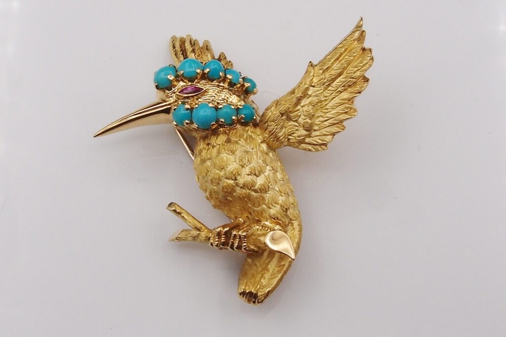 Broche clip oiseau, signée Wolfers ,vers 1960 , or jaune 18 cts , turquoises et rubis .