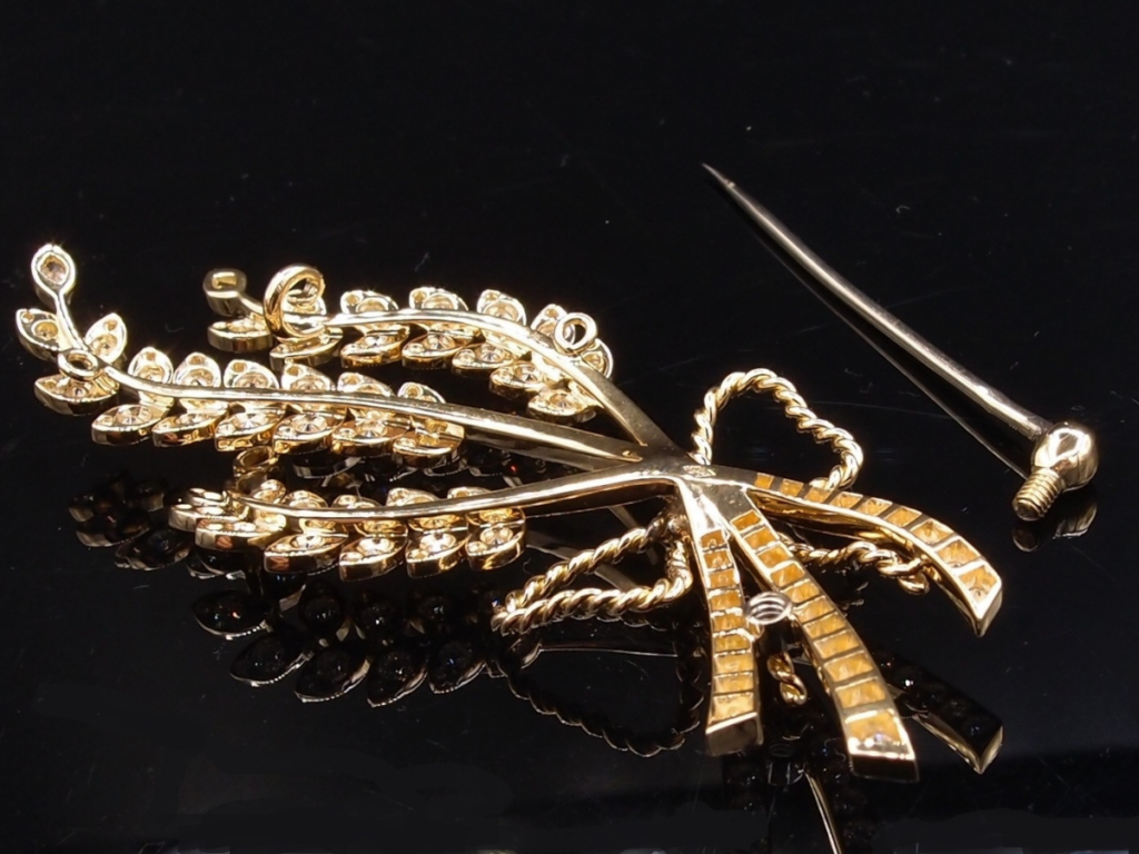 Cette broche épis de blé en or jaune 18 carats, création Van Hoye, incarne toute la finesse et le raffinement de la Haute Joaillerie artisanale parisienne.
Entièrement réalisée à la main dans notre atelier à Paris, cette pièce délicate représente deux épis de blé finement dessinés, délicatement noués par un ruban pavé de diamants. Symbole d’abondance et d’élégance, ce motif intemporel est sublimé par un sertissage de diamants qui apporte éclat et légèreté à l’ensemble.
Chaque détail a été travaillé avec précision pour offrir un bijou aérien, lumineux et parfaitement équilibré. Cette broche en diamants peut se porter aussi bien sur un vêtement qu’en pendentif, pour une allure chic et contemporaine.
Signature du savoir-faire Van Hoye, cette création allie tradition joaillière et modernité.